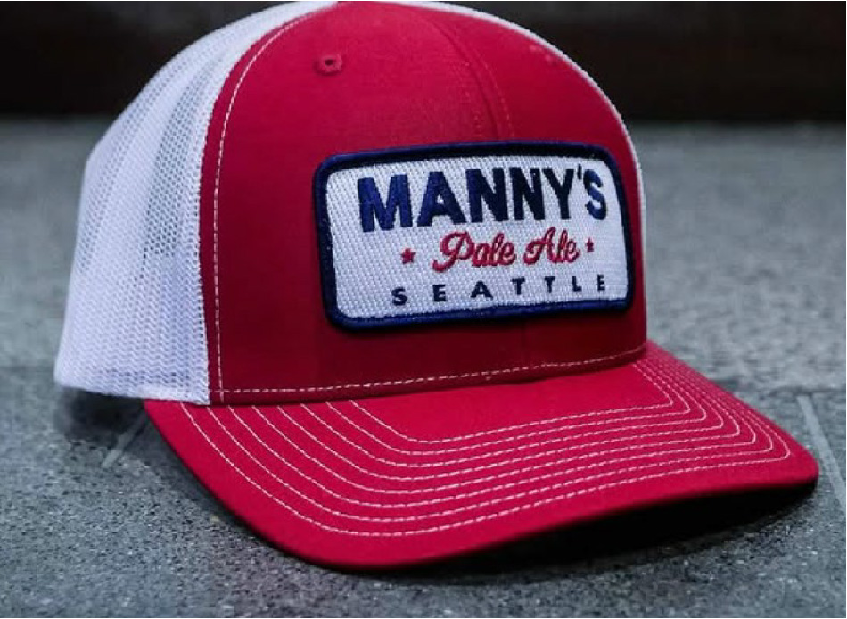Detailed view of embroidered logo stitching on a hat alongside a custom woven patch sewn onto a jacket, illustrating texture, precision, and premium craftsmanship.